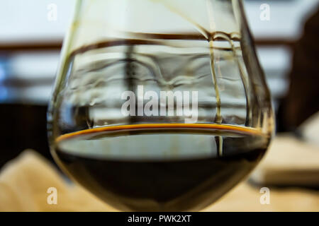 Ein Glas Rotwein auf einem schönen Hintergrund. Ein Glas Wein. Freier Platz für den Text im Hintergrund. Stockfoto