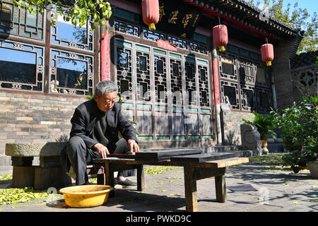 (181017) - PINGYAO, Oktober 17, 2018 (Xinhua) - Handwerker Geng Baoguo Polituren Rohstoffe in seiner Werkstatt in Pingyao, im Norden der chinesischen Provinz Shanxi, am Okt. 16, 2018. Lacquerwares sind Objekte, die dekorativ mit Lack überzogen. Die lackierten lacquerwares in Pingyao sind natürlichen Lack gemacht und lackiert mit einem speziellen hand Technik. Nach einigen Schritten von handwerklichen Techniken, Sie sind mit verschiedenen bunten Mustern verziert und mit Ornamenten installiert. Die Oberfläche der fertigen lacquerwares sind glatt und glänzend. Eine Geschichte von über 1000 Jahren, die pingyao Lackwaren war Liste Stockfoto