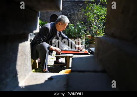 (181017) - PINGYAO, Oktober 17, 2018 (Xinhua) - Handwerker Geng Baoguo Polituren Rohstoffe in seiner Werkstatt in Pingyao, im Norden der chinesischen Provinz Shanxi, am Okt. 16, 2018. Lacquerwares sind Objekte, die dekorativ mit Lack überzogen. Die lackierten lacquerwares in Pingyao sind natürlichen Lack gemacht und lackiert mit einem speziellen hand Technik. Nach einigen Schritten von handwerklichen Techniken, Sie sind mit verschiedenen bunten Mustern verziert und mit Ornamenten installiert. Die Oberfläche der fertigen lacquerwares sind glatt und glänzend. Eine Geschichte von über 1000 Jahren, die pingyao Lackwaren war Liste Stockfoto