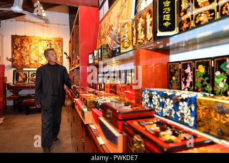 (181017) - PINGYAO, Oktober 17, 2018 (Xinhua) - Handwerker Geng Baoguo ist in seinem lackwaren Store in Pingyao, im Norden der chinesischen Provinz Shanxi, am Okt. 16, 2018. Lacquerwares sind Objekte, die dekorativ mit Lack überzogen. Die lackierten lacquerwares in Pingyao sind natürlichen Lack gemacht und lackiert mit einem speziellen hand Technik. Nach einigen Schritten von handwerklichen Techniken, Sie sind mit verschiedenen bunten Mustern verziert und mit Ornamenten installiert. Die Oberfläche der fertigen lacquerwares sind glatt und glänzend. Eine Geschichte von über 1000 Jahren, die pingyao Lackwaren wurde als einer der aufgeführten Stockfoto