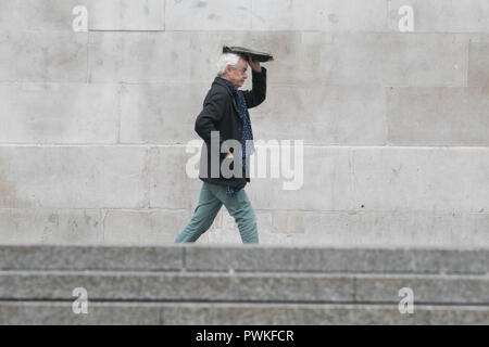 London, Großbritannien. 17. Oktober 2018. Fußgänger Schutz vor dem Regen Nieselregen in Trafalgar Squre London auf einem nassen ovecast Tag Credit: Amer ghazzal/Alamy leben Nachrichten Stockfoto