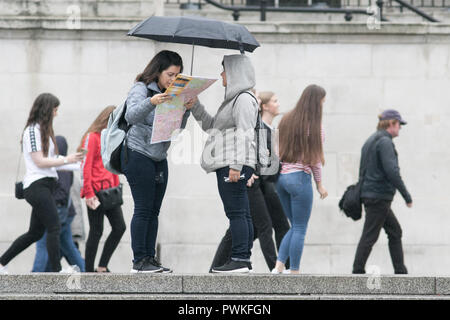 London, Großbritannien. 17. Oktober 2018. Fußgänger Schutz vor dem Regen Nieselregen in Trafalgar Squre London auf einem nassen ovecast Tag Credit: Amer ghazzal/Alamy leben Nachrichten Stockfoto