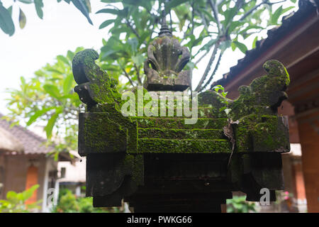 Balinesische Daemon Statue auf einem tropischen Regenwald bedeckt mit Moos. Stockfoto
