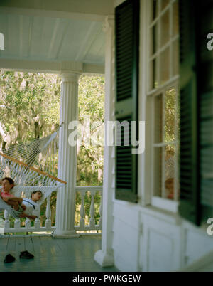 Mitte der erwachsenen Frau mit ihrem Sohn in einer Hängematte. Stockfoto