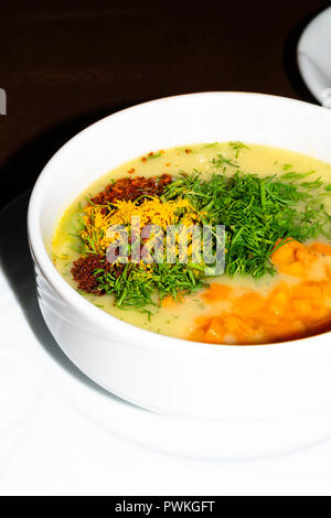 Linsen und Kürbis creme Suppe mit Frischkäse und rotem Pfeffer, Dill in Weiß Schüssel Stockfoto