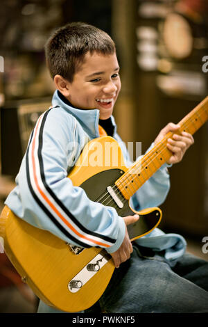 Junge spielt eine E-Gitarre in einem Music Shop. Stockfoto