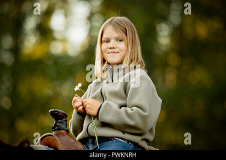 Porträt eines jungen Mädchen, dass eine Daisy auf dem Pferderücken Stockfoto