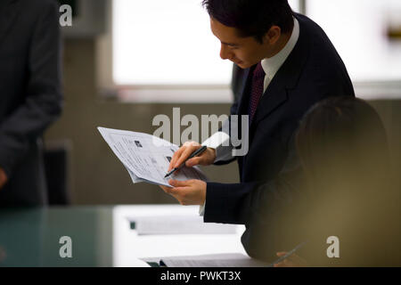Junge Erwachsene Geschäftsmann Dokumente an einen Kollegen. Stockfoto