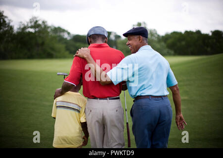 Junge gehen über Golfplatz mit Vater und Großvater Stockfoto