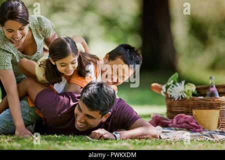 Familie von vier Spielen bei einem Picknick im Park. Stockfoto