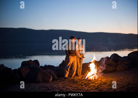 Lächelnd Mann und Frau mit einem Lagerfeuer am Strand. Stockfoto