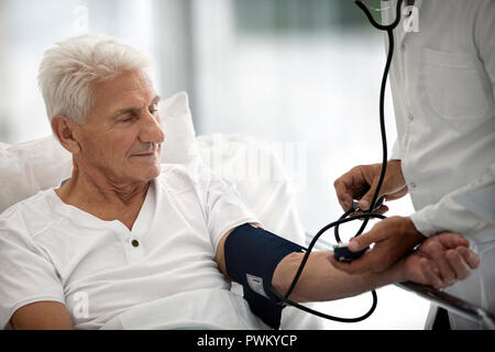 Ältere Menschen im Krankenhaus in seinen Blutdruck. Stockfoto