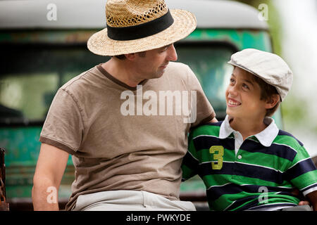 Vater und Sohn nebeneinander sitzen. Stockfoto