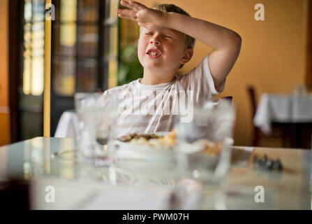 Junge an einem Tisch in einem Restaurant sitzen. Stockfoto