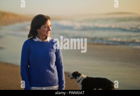 Portrait eines glücklichen, reife Frau, stehend auf einem Strand. Stockfoto