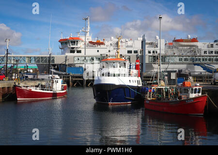 Die riesige Northlink's Ferry Hamnavoe angedockt in Stromness Hafen auf Orkney Mainland, Schottland, mit mehreren anderen Boote, macht eine bunte sonnige Szene. Stockfoto