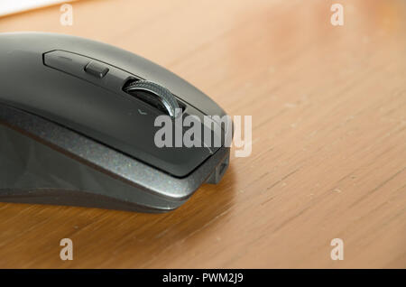 Kabellose Maus mit omnidirektionaler Scrollrad und Seitentasten auf einem Tisch isoliert Stockfoto