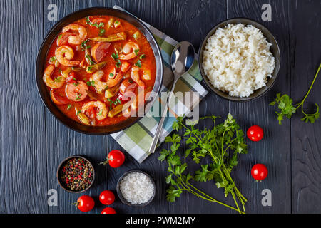 Ansicht von oben der Köstlichen Gumbo mit Garnelen, Okra und Würstchen in einer Schüssel auf einem Schwarzen Tisch serviert mit Schale, weißer Reis, Ansicht von oben, close-up Stockfoto