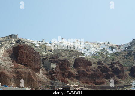 Griechenland, der Insel Santorini. Ein Blick auf die Stadt Oia, thront hoch auf die dramatischen vulkanischen Klippen. Stockfoto