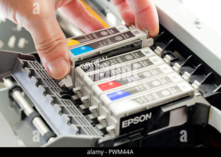 Mann Ersetzen einer Tintenpatrone auf eine Farbe tintenstrahldrucker (Nahaufnahme) - USA Stockfoto