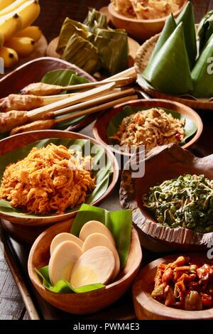 Nasi Jinggo, die Balinesische kleine Mahlzeit aus Reis mit gebratenen Nudeln, Gemüse und Ei umhüllt mit Banana Leaf; mit zusätzlichen optionalen Beilagen serviert. Stockfoto