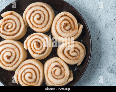 Rohteig Vorbereitung schwedische Zimtschnecken Kanelbullar mit pumpkin Spice bereit zu backen. Idee und Rezept Gebäck - perfekt Zimtrollen, Ansicht von oben in Skillet. Flach. Platz für Text kopieren Stockfoto