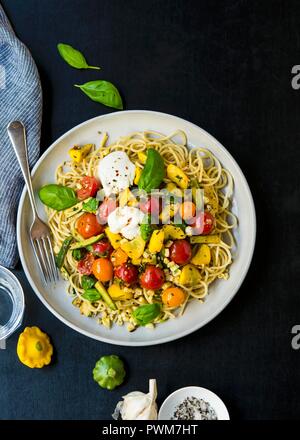 Spaghetti mit Sardellen Paste, sautiertem Gemüse, Burrata und Basilikum Stockfoto