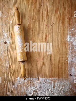 Einer bemehlten Arbeitsfläche aus Holz und einem Nudelholz Stockfoto