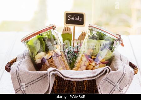 Zwei Salate in Töpfen in eine bascket in ein Buffet für einen Brunch vorbereitet Stockfoto