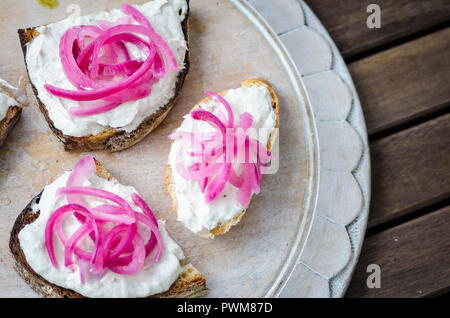 Bruschetta geröstete Scheiben Baguette, Ciabatta und Sauerteigbrot mit Makrelen Pastete und eingelegte rote Zwiebel Stockfoto