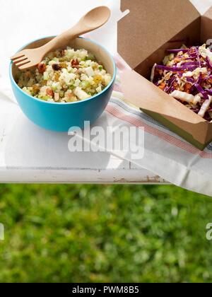 Zwei seitliche Salate auf einem Tisch im Freien; Quinoa Salat und Cole Slaw Stockfoto