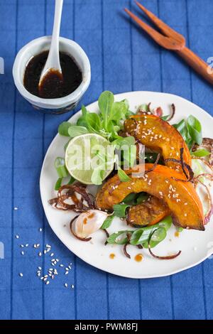 Gebackenem Hokkaido Kürbis Keile mit Feldsalat und Sojasauce Stockfoto