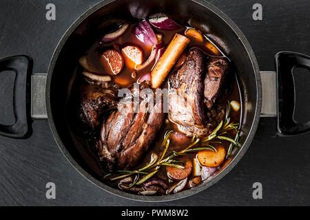 Lammkeule in Rotwein mit Zwiebeln, Karotten und Rosmarin Stockfoto