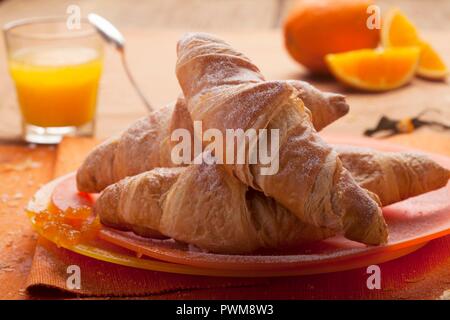 Frische Croissant mit Marmelade mit frisch gepresstem Orangensaft serviert. Stockfoto