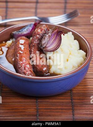 Gebratene Würstchen mit Kartoffelbrei und Soße Stockfoto