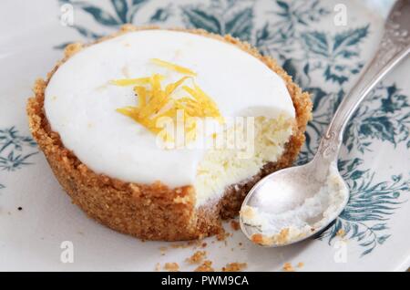 Einen Käsekuchen Törtchen mit einem Bissen genommen Stockfoto