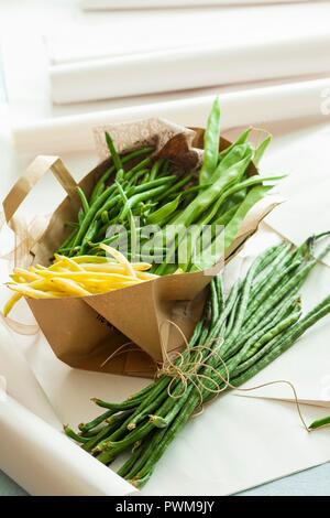 Verschiedene Arten von Bohnen in eine Papiertüte und daneben Stockfoto