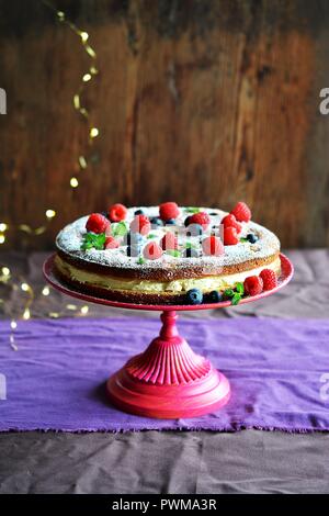 Keks Kuchen mit Waldfrüchten und Sahne auf einem Ständer Stockfoto