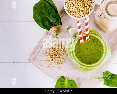 Draufsicht der grünen Smoothie in Einmachglas auf weißen Tisch. Frischen grünen Smoothie mit grünen Buchweizen, Spinat und vegane Milch. Kopieren Sie Raum. Vertikale. Stockfoto