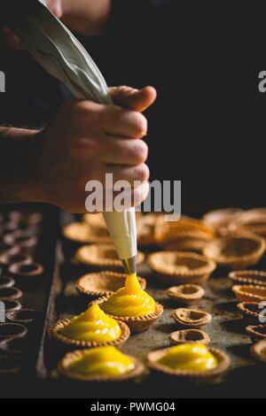 Mürbeteig Törtchen mit Vanillecreme gefüllt werden Stockfoto