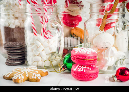 Satz von verschiedenen Weihnachten Süßigkeiten, Lebkuchen, Plätzchen, Macarons, Eibisch mit heißer Schokolade Zutaten, in Mason jar Gläser, weisser Hintergrund co Stockfoto