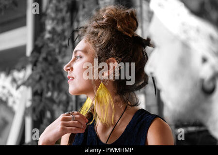 Ansprechend elegante dunkelhaarige Frau mit Haar bun tragen schöne Ohrringe Stockfoto