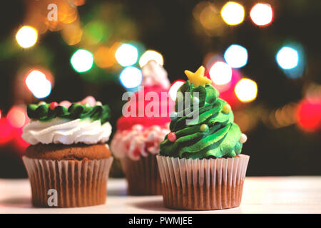 Cupcakes für Weihnachten dekoriert, gegen bunte bokeh Hintergrund; Urlaub Hintergrund Stockfoto