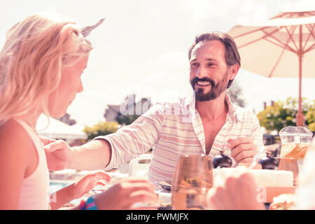 Freudige positiver Mann seine Töchter Hand berühren. Stockfoto