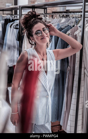 Strahlende glückliche Frau tragen blau gestreiften Kostüm Einkaufen in Favoriten Boutique Stockfoto