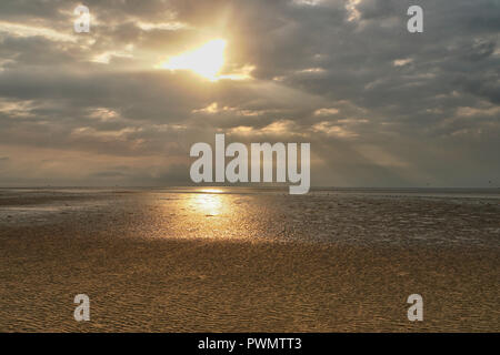 Golden sunrise auf Galveston Beach mit dem Sun Streaming durch die Wolken Stockfoto