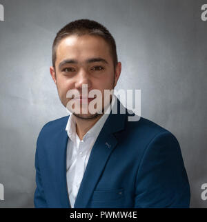 Stattliche erfolgreicher Geschäftsmann in blauen Anzug sitzen und Ausdrücke Stockfoto