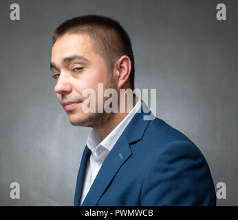 Stattliche erfolgreicher Geschäftsmann in blauen Anzug sitzen und Ausdrücke Stockfoto