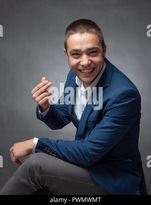 Stattliche erfolgreicher Geschäftsmann in blauen Anzug sitzen und Ausdrücke Stockfoto