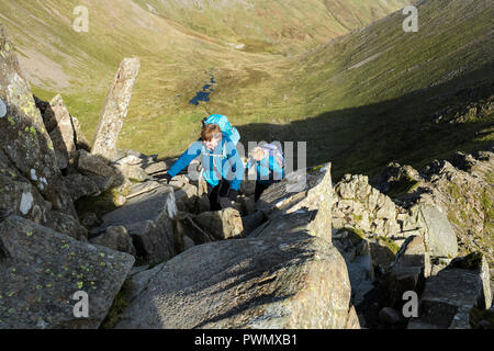 Zwei Menschen, die Kriechen auf Swirral Kante, Helvellyn, Lake District, Cumbria, UK. Stockfoto